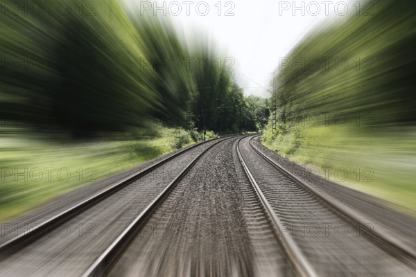 double-track railroad railway or train tracks with speed motion blur - fast travel concept background with copy space