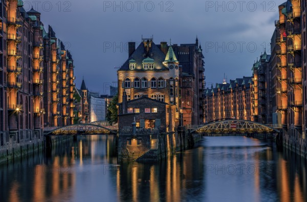 View of the Speicherstadt at night in Hamburg, Germany. Illuminated Speicherstadt seen from the Poggenmühlen Bridge