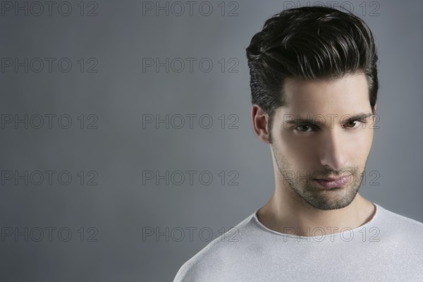Fashion trendy young man silver futuristic portrait over gray