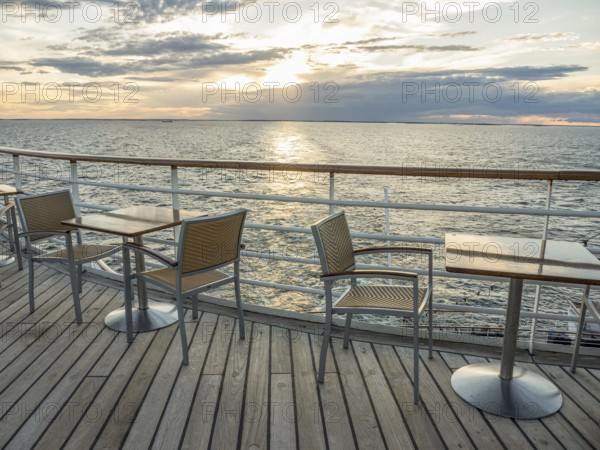 Terrace on the sea at sunset, empty tables and chairs, quiet atmosphere, svaneke, bornholm, baltic sea, denmark, scandinavia
