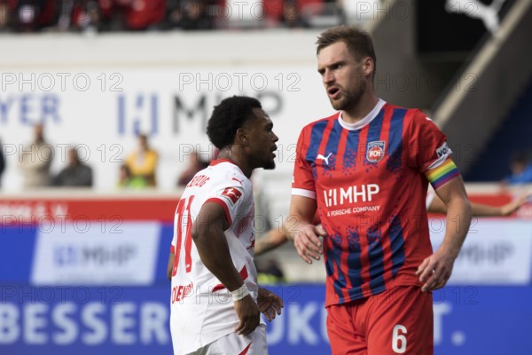 Football match, Lois OPENDA RB Leipzig left with captain Patrick MAINKA 1.FC Heidenheim in opposite direction, football stadium Voith-Arena, Heidenheim
