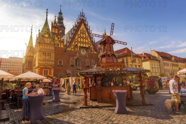 Wroclaw, Poland, June 21, 2019: Old Town Hall and decorative windmill at Market Square, stalls with food and drinks, people, Europe