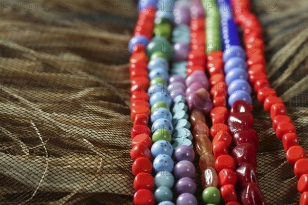Color stones jewelry necklaces over natural straw and tulle background