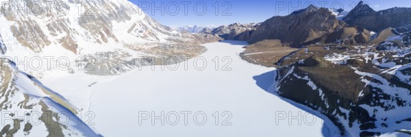 Aerial view of high altitude Tilicho Lake frozen and covered with snow in the Himalaya mountains of Nepal