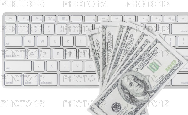 US hundred dollar bills with white computer keyboard isolated on white background