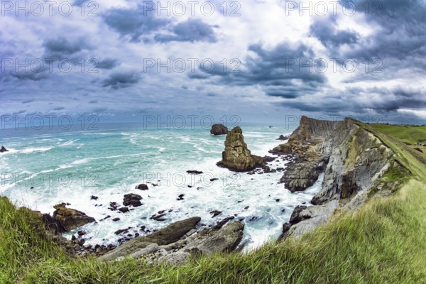 Powerful surf waves with a foam crest. Dramatic stormy sky. Cantabria Beaches, Portio Beach. Windy stormy day on the Atlantic coast. Noon on the beach of Playa di Arnia, Spain, Europe