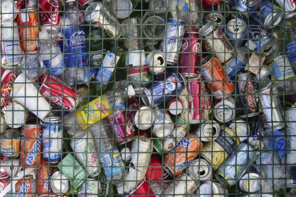 Assorted beverages cans on the trash, colored texture
