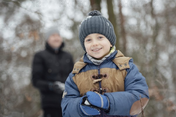 Six year old boy smiling during makeing snowball