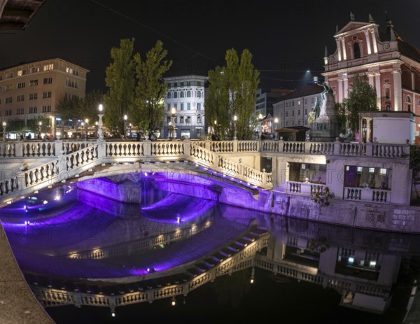 Famous three bridges at the Preseren square in the center of Ljubljana colorfully illuminated at night, Slovenia, Europe