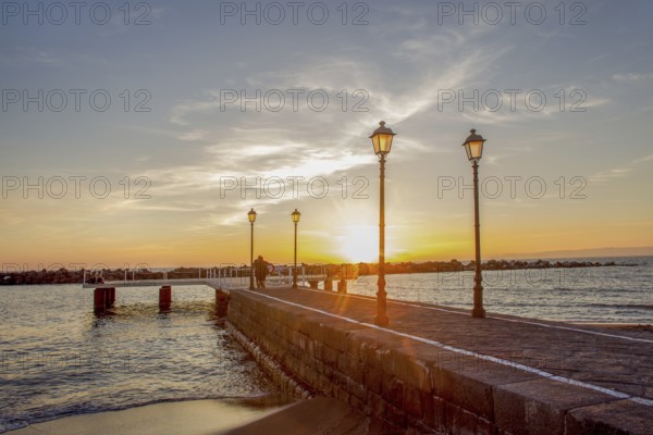 Orange unset at Gulf of Naples>Pirs and Lamps and recognizable people at far distance