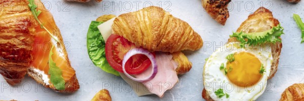 Croissant sandwich variety panorama. Different stuffed croissants, overhead flat lay shot. Rolls filled with ham, salmon, egg, etc, Food photography, Food photography