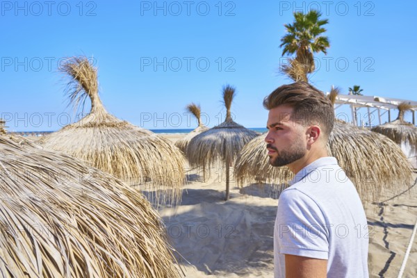 Young beard man in a beach with parasol at summer