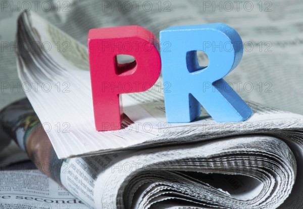 Word PR on newspaper. Wooden letters
