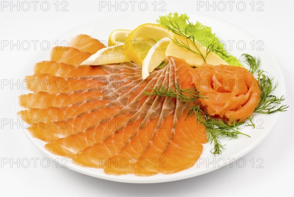 Sliced smoked salmon served with lemon and salmon rose