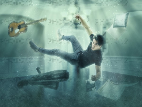 Illusion of man floating underwater among objects in room looking at camera