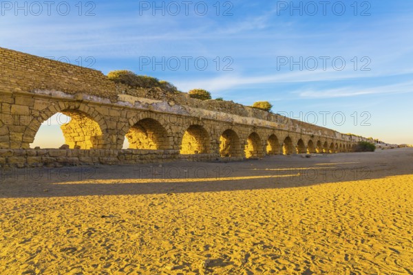 High aqueduct, built under the reign of Herod the Great. Concept of active, ecological and historical tourism. Fantastic sunset on the Mediterranean coast in Caesarea