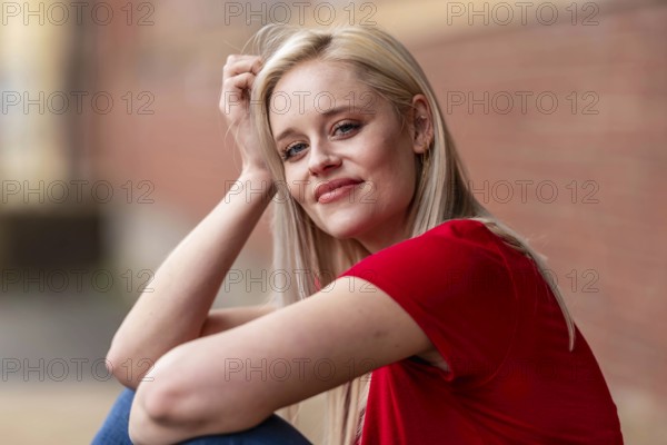 A beautiful blonde woman poses joyfully for the camera, showcasing her stylish spring clothing. With a bright smile and playful demeanor, she radiates happiness, embracing the upcoming gorgeous weather, Charlotte, United States of America