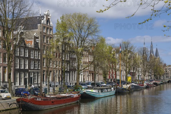 View of Amsterdam canal with historic houses and boat, Netherlands