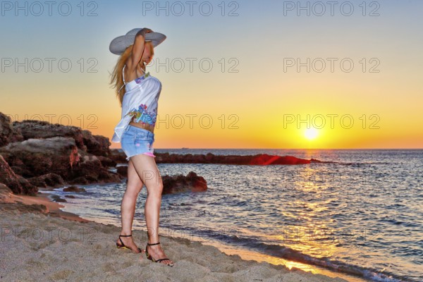 A beautiful woman at the sunset on the beach Falassarna of Creta, Greece, Europe