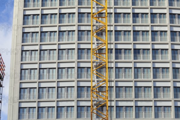 Construction crane in front of the window front of a high-rise building, Bremen, Germany, Europe
