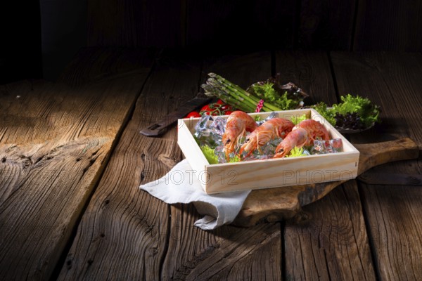 Cooked argentine red prawns with salad on the ice