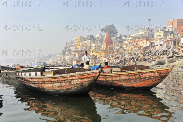 Varanasi, Uttar Pradesh, India, Asia, Two boats floating side by side on a river with urban scenery in the background, Asia