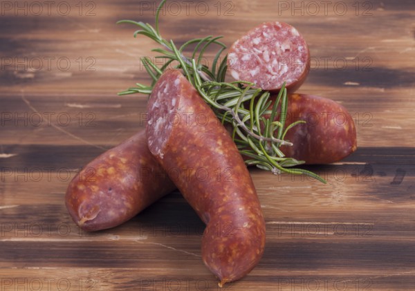 Image shows smoked sausages on a vintage wooden plate