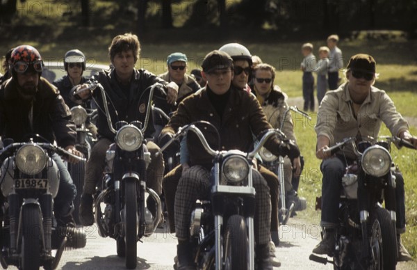 In the 1960s. Motorcyclists on the road together. Cool and trendy looking riding thir bikes. The law of wearing a safety helmet is not yet in force and at this time it was popular to wear caps. The jacket is typical 1960s with a wool collar. Sweden 1968. ref CV31