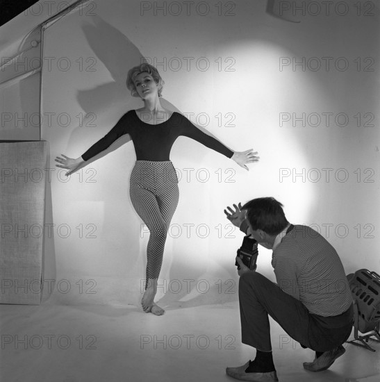 1950s photographer. A woman is posing for a photographer wearing a typical 1950s black jumper and patterned trousers. Sweden 1958. Ref CC96-2