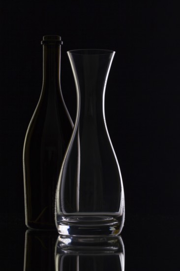 Empty glass and bottles on the black background