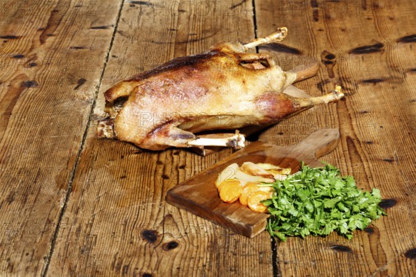 Roasted goose on wooden table