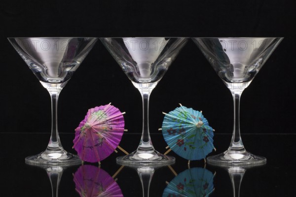 Three empty glasses of champagne with decoration (paper umbrellas)