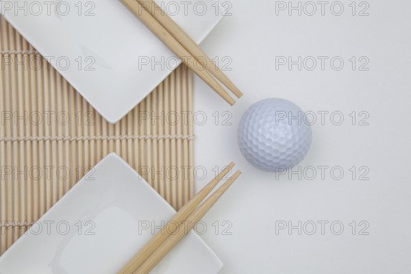 Top View Of White Empty Sushi Plates With Bamboo Chopsticks and Golf Ball. Golf Design