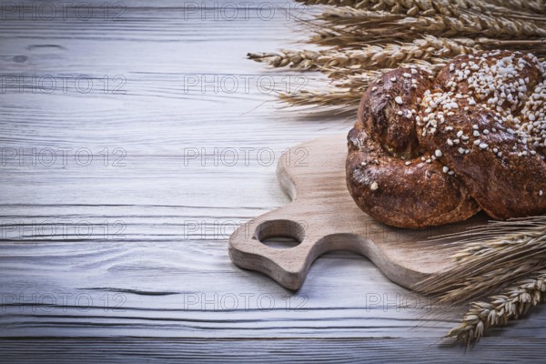 Chopping board wheat rye ears bread stick on wooden background