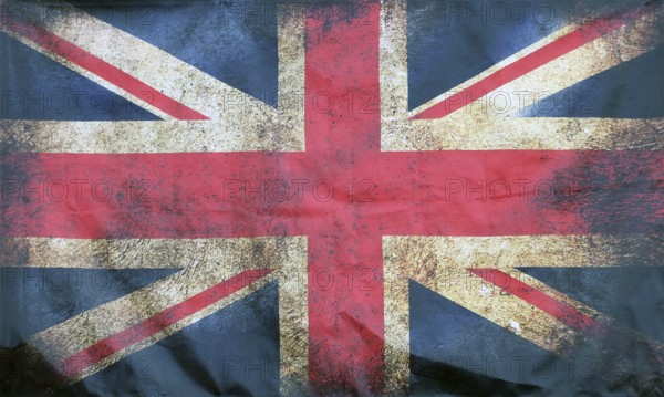 A full frame image of an old stained dirty union jack british flag with dark crumpled edges