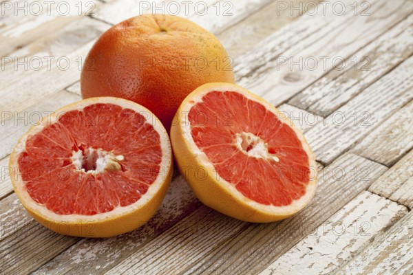 Red cut grapefruit on white grunge wood table with paint peeling off