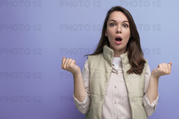 Schockiert kaukasische junge brünette frau in lässigen kleidung mit offenem mund auf studio hintergrund