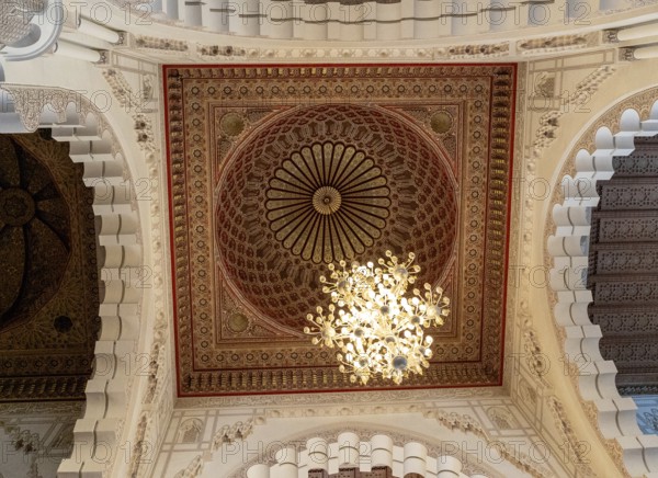 Casablanca, Morocco, 29 March, 2024: detail view of an ornate cedarwood ceiling and chandelier insidev the Hassan II Mosque in Casablanca, Africa