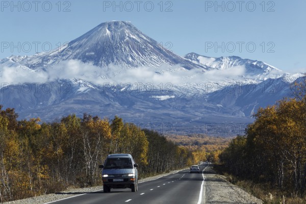KAMCHATKA, RUSSIA, SEP 30, 2012: Autumn view of cars on driving road to active Avachinsky Volcano on Kamchatka Peninsula on sunny, cloudless day with blue skies. Russian Federation, Far East