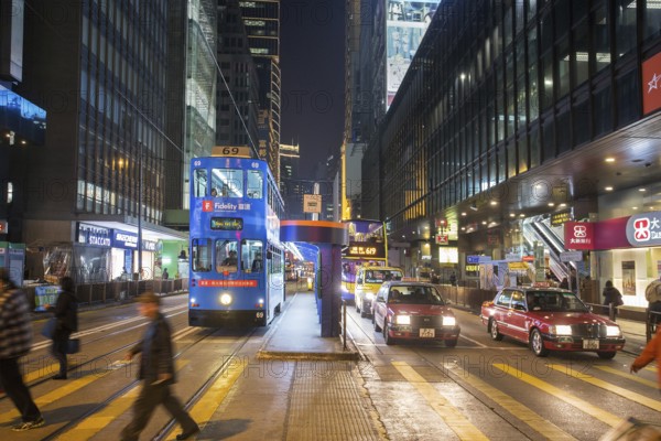 Unrecognizable people, moving, blurred. HongKong, is people anthill ! Double-deck, is tram -left, and bus, right