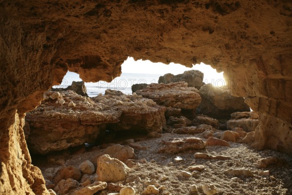 Cave entrance view from interior with light coming in, beach