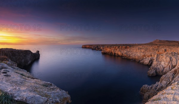Landscape view of cliffs and rugged shorelina at Pont d'en Gil in northeastern Menorca near Ciutadella at sunset