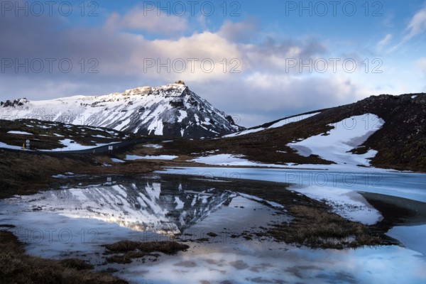 Icelandic landscape with frozen lake and stapafell mountains covered in snow and reflected on water at snaefellsnes peninsula in Iceland