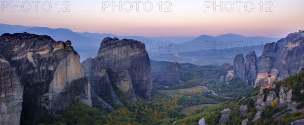 Panoramic view of majestic rock formations and a valley with a monastery at dusk, Meteora valley with monasteries, Trikala, Thessaly, Greece, Europe