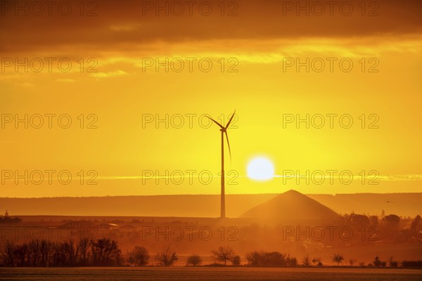 Sunrise with a view of wind turbines and mining heaps from the copper mines in the south of the Harz Mountains
