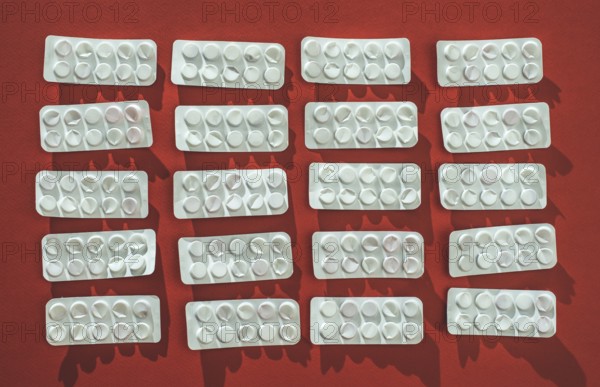 Packs of pills on red background