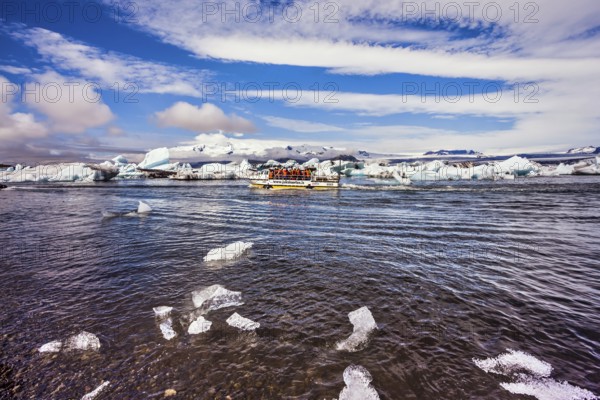 The trash-ice on Jokulsarlon, Iceland. Striped clouds beautifully reflected in the smooth water of lagoon. The concept of northern extreme tourism