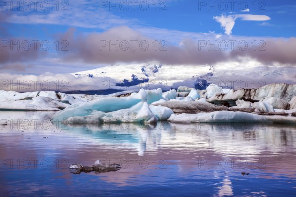 The concept of extreme northern tourism. Ice floes are reflected in the smooth water surface of Ice Lagoon