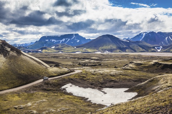Summer trip to Iceland. The dirt road in a valley surrounded by mountains
