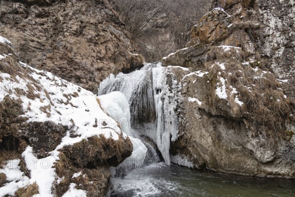 The waterfalls, which are not completely frozen in winter, flow down from the porous rocks